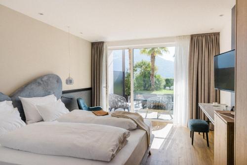 Habitación de hotel con 2 camas y balcón en Hotel Paradies, en Tirolo