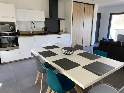 une cuisine et un salon avec une table et des chaises dans l'établissement Appartement avec terrasse et parking privé logement C, à Ploemeur