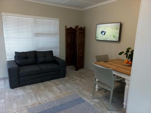 sala de estar con sofá y mesa en Lazy Days Apartments - Jeffreys Bay, en Jeffreys Bay