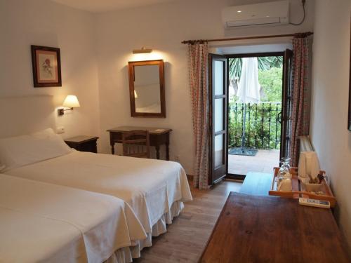 a hotel room with two beds and a sliding glass door at Molino Del Santo in Benaoján