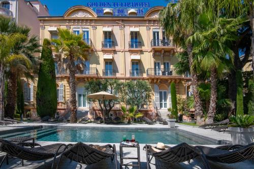un hôtel avec une piscine en face d'un bâtiment dans l'établissement GOLDEN TULIP CANNES HOTEL de PARIS, à Cannes