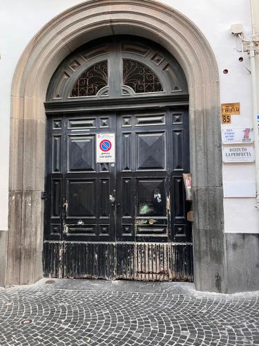 a large black door of a building with a no entry sign at Studio loft 85 in Torre Annunziata