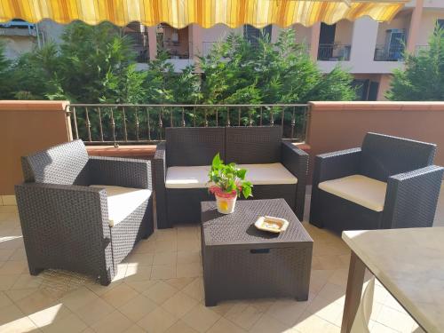 a patio with wicker chairs and a table and a tableasteryasteryasteryastery at B&B Delle Serre in Messina