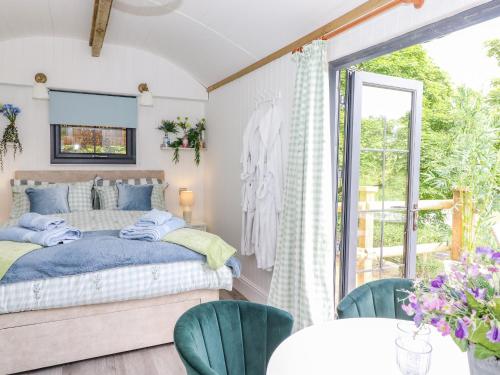 a bedroom with a bed and a table and chairs at High Rigg Shepherd's Sunrise in Brampton