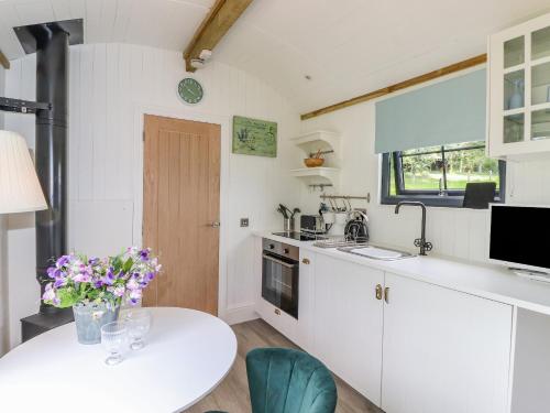 a kitchen with a table and a white counter top at High Rigg Shepherd's Sunrise in Brampton