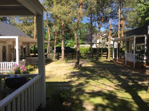a porch of a house with a yard with trees at Domki nad morzem Sasino Mojo Miodno Checz in Sasino