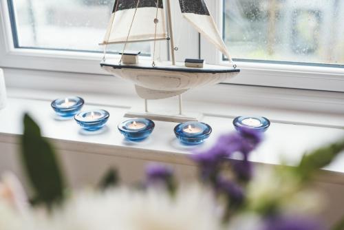 a toy boat sitting on a counter next to a window at Waves - Sea View Duplex Apartment, Stoke Fleming in Stoke Fleming