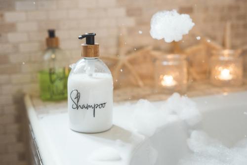 a white soap bottle sitting on a bathroom sink at Waves - Sea View Duplex Apartment, Stoke Fleming in Stoke Fleming