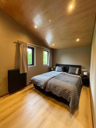 ein Schlafzimmer mit einem großen Bett und Holzboden in der Unterkunft Luitekamp Ameland in Ballum