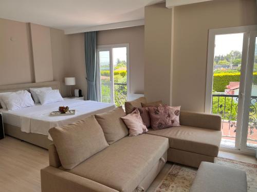 a living room with a bed and a couch at B. Equine Range Hotel in Narlıdere
