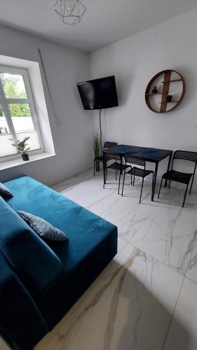a living room with a blue bed and a table at Apartament Królewiecka 22 Centrum Molo jezioro Czos in Mrągowo