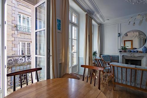 d'une salle à manger avec une table et quelques fenêtres. dans l'établissement Appartement de la Tour de l'Horloge de DINAN, à Dinan