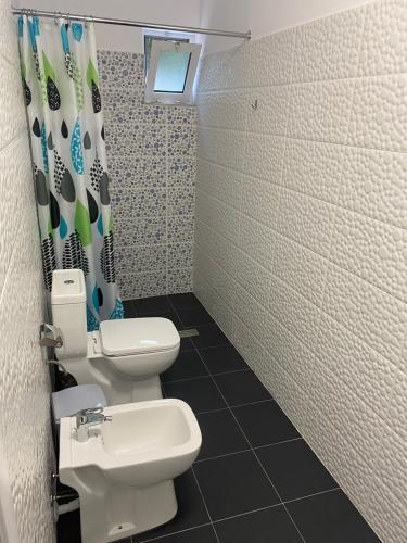 a bathroom with two toilets and a shower curtain at Vila Ajdinaj in Berat