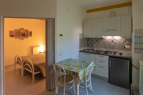 uma pequena cozinha com uma mesa e uma mesa e cadeiras em Residence Ranieri em Castiglione del Lago