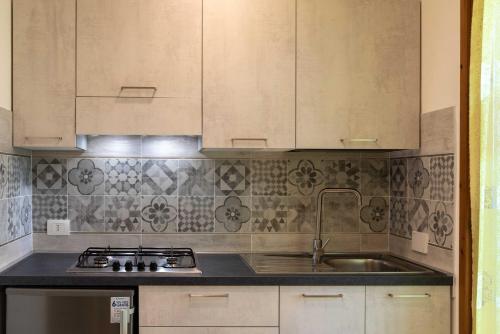 a kitchen with white cabinets and a sink at Residence Ranieri in Castiglione del Lago