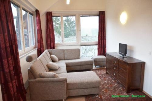 a living room with a couch and a chair at Ferienwohnung Herrmann Pottenhofen in Pottenhofen