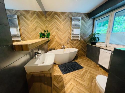 a bathroom with a white tub and a sink at Apartament Góry i Potok in Porąbka