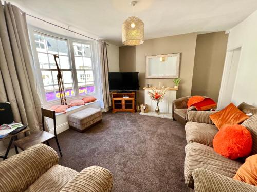 a living room with two couches and a television at Gigi's Place in Weymouth