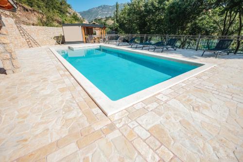 a swimming pool with blue water in a backyard at River huts Zrmanja in Obrovac