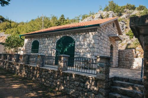 a stone building with a fence on a wall at River huts Zrmanja in Obrovac