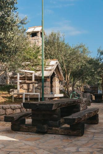 a stone building with a picnic table and a pole at River huts Zrmanja in Obrovac