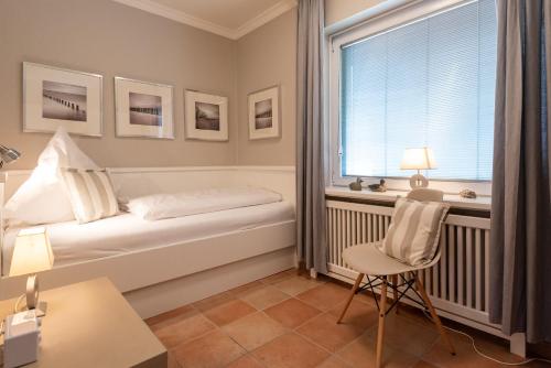 ヴェニングシュテットにあるC-Haus Christine, App 20のベッドルーム1室(ベッド1台、窓、椅子付)