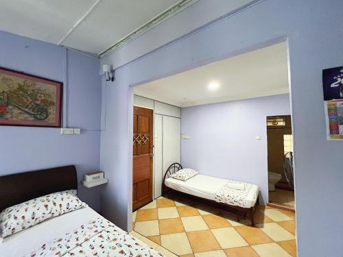 a bedroom with blue walls and a bed and a mirror at Merdeka Guest House 2 in Kuching