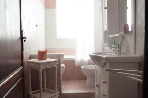 uma casa de banho branca com um WC e um lavatório em Appartamento La sosta em San Romano