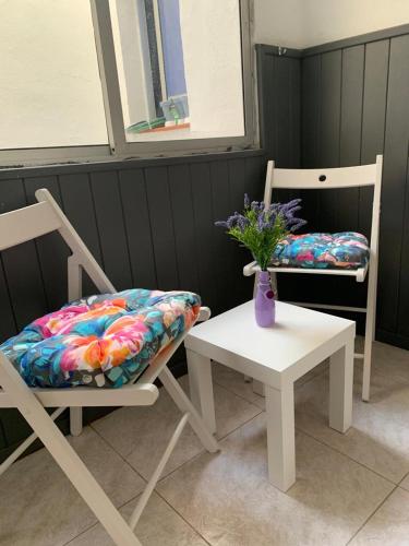 two chairs and a table with a vase of flowers at TRES habitaciones privadas 4huéspedes 4huéspedes 2huéspedes piso a compartir in Las Lagunas