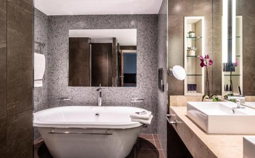 a bathroom with a white tub and a sink at Norton House Hotel & Spa, Edinburgh in Ingliston