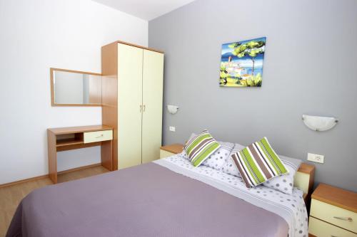 um pequeno quarto com uma cama e um espelho em Apartments Fjolla em Labin