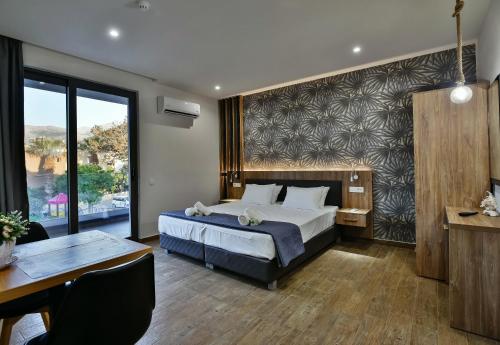 a hotel room with a bed and a table and a desk at Del Mar 'Adults Only' in Stalida