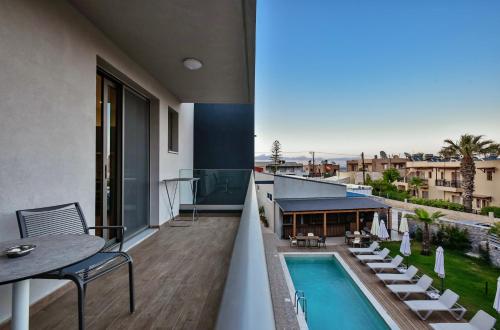 a balcony with a pool and a table and chairs at Del Mar 'Adults Only' in Stalida