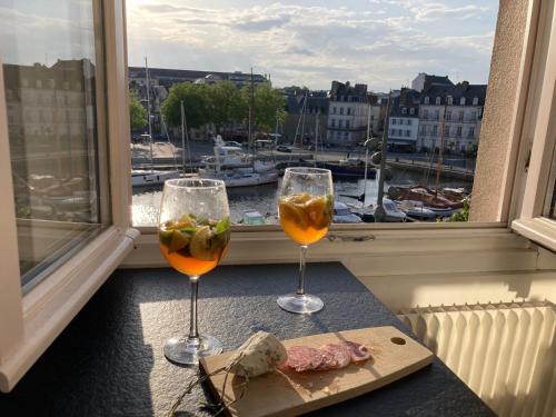 - deux verres de vin assis sur une table avec une fenêtre dans l'établissement La magie du Port de Vannes et son centre historique à pied et 2 places de parking en souterrain, à Vannes