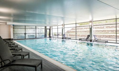 a large swimming pool with chairs in a building at Norton House Hotel & Spa, Edinburgh in Ingliston
