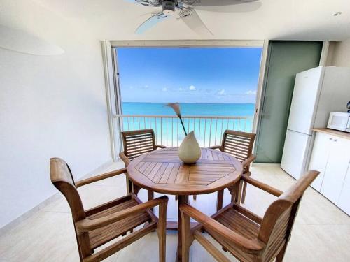 a dining room with a table and chairs and a window at Pavillon Beach 9, feet in the water in Grand Case in Grand Case