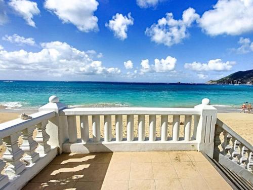 a balcony with a view of the beach at Pavillon Beach 9, feet in the water in Grand Case in Grand Case