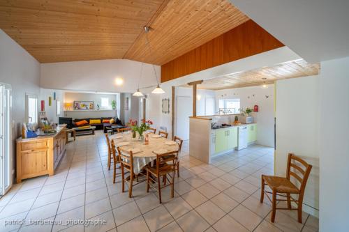 une cuisine et un salon avec une table et des chaises dans l'établissement Les Gîtes de Sophie 85 Gîte Hortensia, à Saint-Gervais