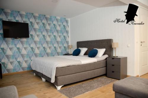 a bedroom with a bed and a flat screen tv at Hotel Kavalir in Žepče
