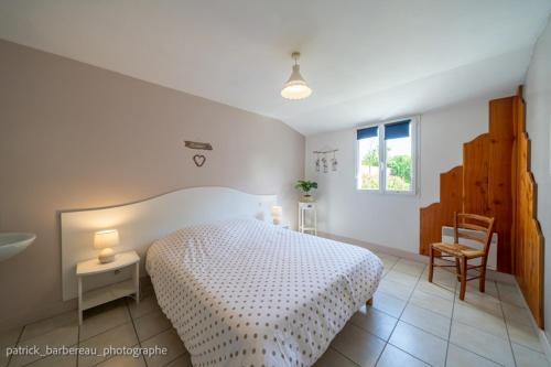 une chambre avec un lit, une table et une chaise dans l'établissement Les Gîtes de Sophie 85 Gîte Hortensia, à Saint-Gervais
