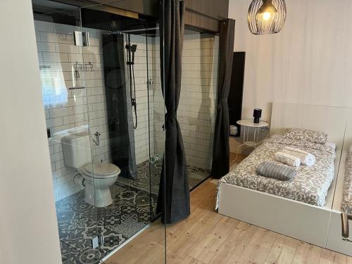 a bathroom with a shower and a bed and a toilet at 4 STARS ROOMS Near Airport in Ščitarjevo