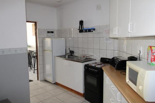 a kitchen with white appliances and a black stove top oven at Sunset Beach 34 in Margate