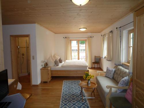 a living room with a bed and a couch at Gästehaus Johanna in Bad Wiessee