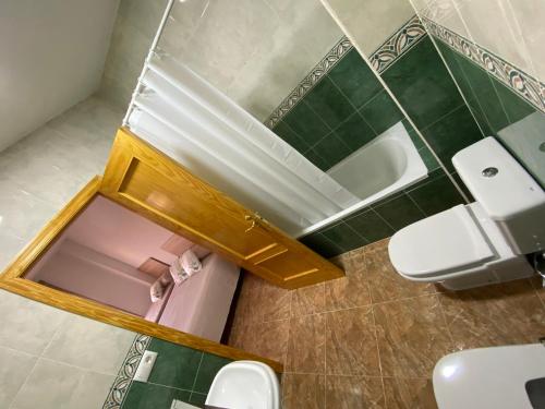 a bathroom with two toilets and a sink and a mirror at Casa Luz De Alba in Calabardina