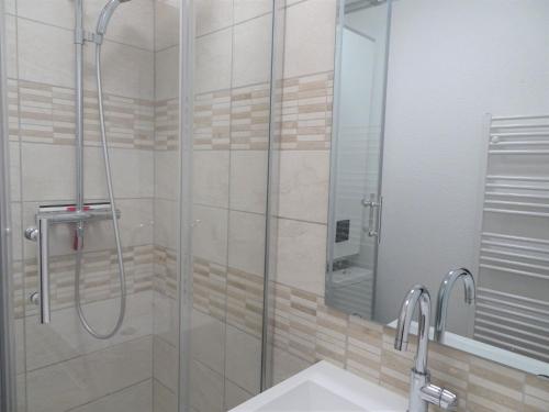 ein Bad mit einer Dusche, einem Waschbecken und einem Spiegel in der Unterkunft Charming maisonette in duplex, 400 m from the beach in Courseulles-sur-Mer