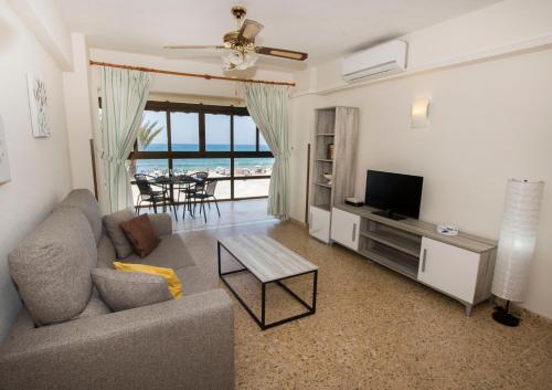 a living room with a couch and a television at Edificio Calpemar in Calpe