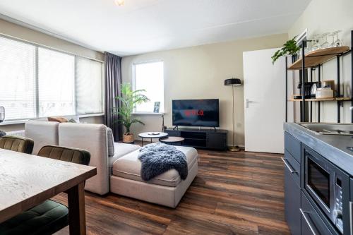 a living room with a couch and a tv at The Lion King - 6 Person linked apartment with roof terrace in Groningen
