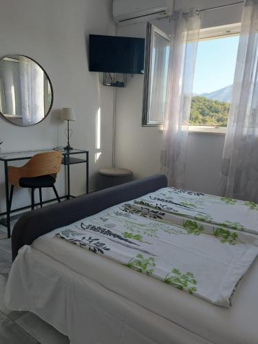 a bedroom with a large bed with a window at Apartman LUCIJA in Korčula