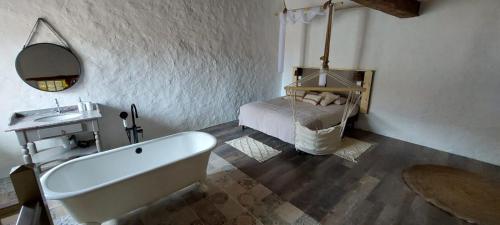 a bathroom with a bath tub and a bed at Maison d'Hôtes Ferme d'Issonges B&B in Marigny-en-Orxois