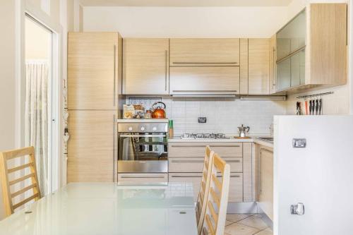 布斯托阿西齊奧的住宿－Residenza Liliana，厨房配有木制橱柜和玻璃桌